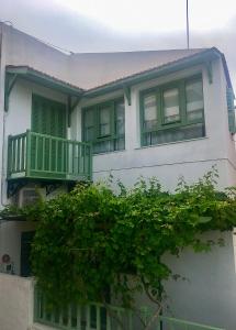 科里夏The house in the port的白色的房子,上面设有绿色的阳台