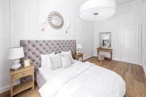 克拉科夫Apartament Golden Place的白色卧室设有一张大床和镜子
