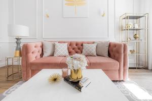 克拉科夫Apartament Golden Place的客厅配有粉红色的沙发和桌子