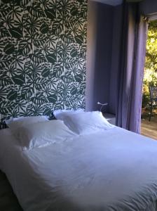 勒芒景点木屋住宿加早餐旅馆的卧室配有白色的墙壁床