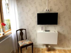 HenånVilla Frideborg的一间房间,墙上有椅子和电视