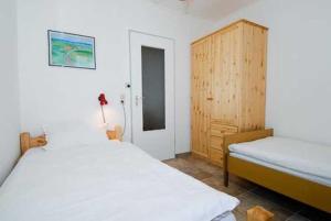 贝塞尔Ferienhaus Nordwind的一间卧室设有两张床和木制橱柜
