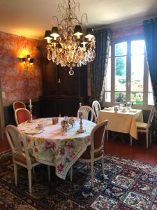 多维尔图尔热维尔狮子庄园酒店的一间带桌椅和吊灯的用餐室