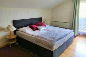 维也纳沃尔夫伦度假屋的一间卧室配有一张带红色枕头的大床