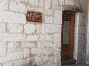 乌奇希萨尔Pigeon Hotel Cappadocia的砖墙,上面有木门