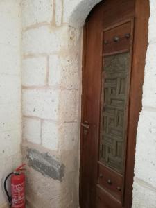 乌奇希萨尔Pigeon Hotel Cappadocia的木门在房间的角落里