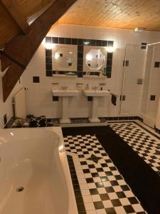 Huigsloot德卡吉斯柯尔住宿加早餐旅馆的浴室配有两个盥洗盆和浴缸。