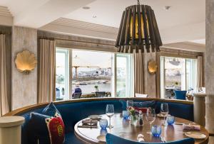 圣莫斯The Idle Rocks的餐厅设有木桌和蓝色椅子
