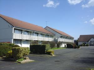 圣莫尔Kyriad Châteauroux - Saint-Maur的一座大型白色建筑,设有停车场