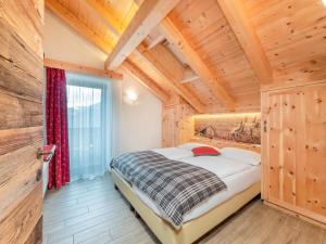 拉瓦莱卡萨劳特公寓的一间带一张床的卧室,位于带木制天花板的房间内