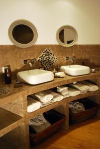 卡代纳阿尔伯特住宿加早餐旅馆的一间带两个盥洗盆、镜子和毛巾的浴室