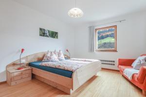 圣马蒂诺Kelderer Hof - Appartment Meran的一间卧室配有一张木床和一张沙发