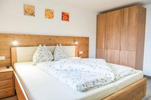圣马蒂诺Hofschenke Pfeiftal - Almenrausch的卧室配有一张白色大床和木制床头板