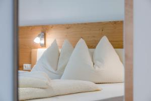 圣马蒂诺Hofschenke Pfeiftal - Hofblick的一张带白色枕头和木制床头板的床