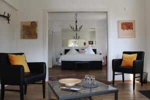 特里滕海姆加莱里斯林酒店的客厅配有床、两把椅子和一张桌子