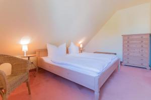 欧巴德伍斯图Ferienhaussiedlung Strandperlen Buchenhof 4d (Typ IV)的卧室配有白色的床和梳妆台。