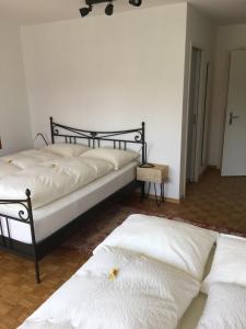 罗曼斯霍恩Lakelodge-Romanshorn 2的配有白色床单的客房内的两张床