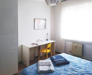 伊夫雷亚Appartamento Ivrea Centro - Sito UNESCO的卧室配有1张床、1张桌子和1把椅子