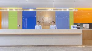 成都临空智选假日酒店(成都双流国际机场店)的两个女人站在一个柜台后面
