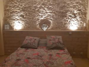 尼姆Suite Privée Bed and Breakfast的一张带两个枕头的床和一个带灯的墙壁