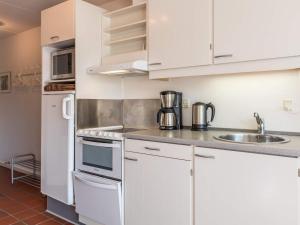 凡岛Holiday home Fanø LIII的厨房配有白色橱柜、水槽和冰箱。