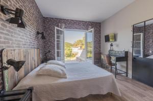 Mourèze莱斯豪特斯莫雷兹酒店的一间卧室设有一张床和砖墙