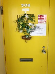 OyamaFuji Subashiri Condominium Tannpopo的黄色的门,上面有盆栽植物