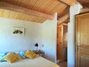 法扬斯La Ferme Constantin的一间卧室设有一张床和木制天花板