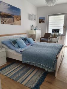 波别罗沃Apartament Bursztyn的一间卧室配有一张带蓝色棉被的大床