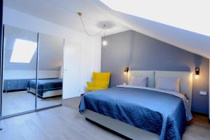 波亚纳布拉索夫Marmot apartment up & down的一间卧室配有蓝色的床和黄色的椅子