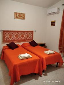 奥列纳B&B San Francesco的配有橙色床单的客房内的两张床