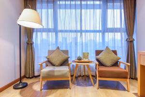 重庆重庆静时文化酒店的客厅设有两把椅子、一张桌子和大窗户