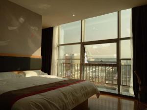 池州尚客优酒店安徽池州站前区火车站店的一间卧室设有一张床和一个大窗户