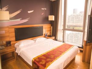 郑州尚客优酒店河南郑州郑东新区东站店的一间卧室设有一张大床和一个大窗户