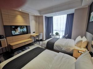 赣州尚客优品江西赣州章贡区宝能城店的酒店客房设有两张床和一台平面电视。