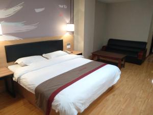 玉树尚客优酒店青海玉树州玉树县康巴商贸城店的酒店客房设有一张大床和一张沙发。