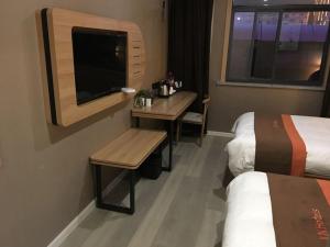 阜阳骏怡连锁安徽阜阳颍上县管仲大道店的酒店客房设有两张床、一张桌子和一张书桌。