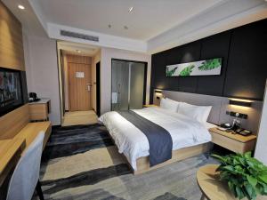 赣州尚客优品江西赣州章贡区宝能城店的酒店客房设有一张大床和一张书桌。