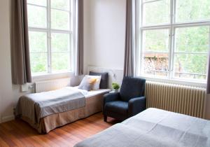 阿尔维卡十一宾馆的一间卧室设有两张床、一把椅子和窗户。