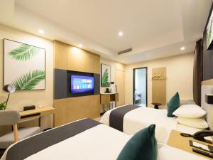 绵阳尚客优品四川绵阳塞纳阳光高铁站店的酒店客房设有两张床和一台平面电视。