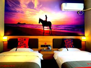 天津骏怡连锁天津津南区大学城平凡道店的卧室,上面画着在海滩上骑马的人的画