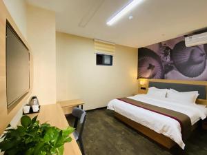 苏州尚客优酒店江苏苏州高新区马涧新天地店的酒店客房设有一张大床和一张桌子。