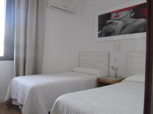 塔里法维拉纽瓦旅馆的一间设有两张床的房间和一幅女人的画
