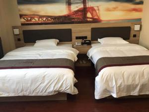 南京尚客优酒店江苏南京江宁区陶吴店的墙上画画的房间里设有两张床