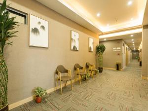 西安尚客优酒店陕西西安未央区高铁北客站店的医院里的一个有椅子和植物的等候区