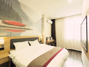 西安尚客优酒店陕西西安未央区高铁北客站店的酒店客房设有一张床,墙上挂有绘画作品