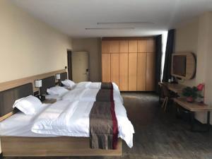南京尚客优酒店江苏南京江宁区陶吴店的一间大卧室,配有一张大床和一台电视