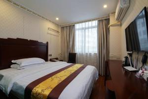 深圳骏怡连锁广东深圳盐田区中英街店的酒店客房设有一张大床和一台电视。