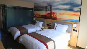 Kaiba尚客优酒店青海海西州乌兰县兴海商业街店的两张位于酒店客房的床,墙上挂着一幅画