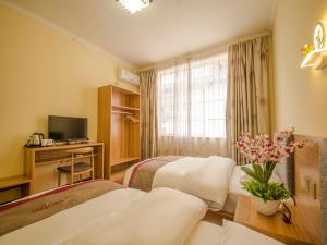 丽江尚客优酒店云南丽江古城区大水车北门店的酒店客房设有两张床和电视。